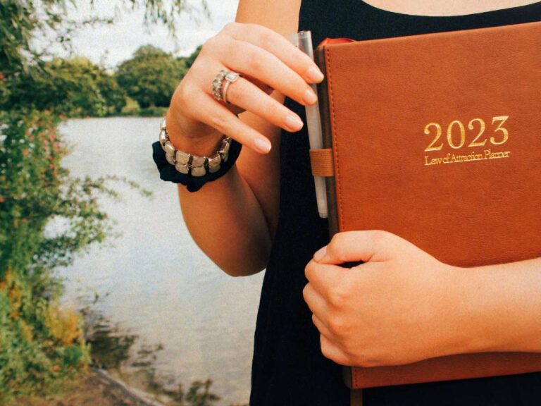 Lucie holding her Deluxe Law of Attraction 12-Month Planner and learning to let go of perfectionism