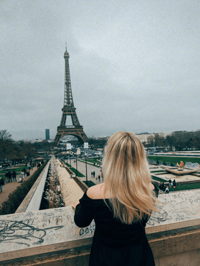 Lucie looking at the Eiffel Tower, inspiring the writing of, "Your guide to visiting Paris in March"