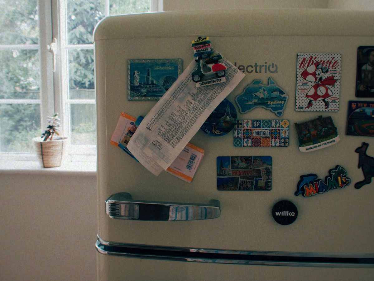 A fridge/freezer in Lucie's home, with a receipt under one of the magnets to signify the cost to decorate a house