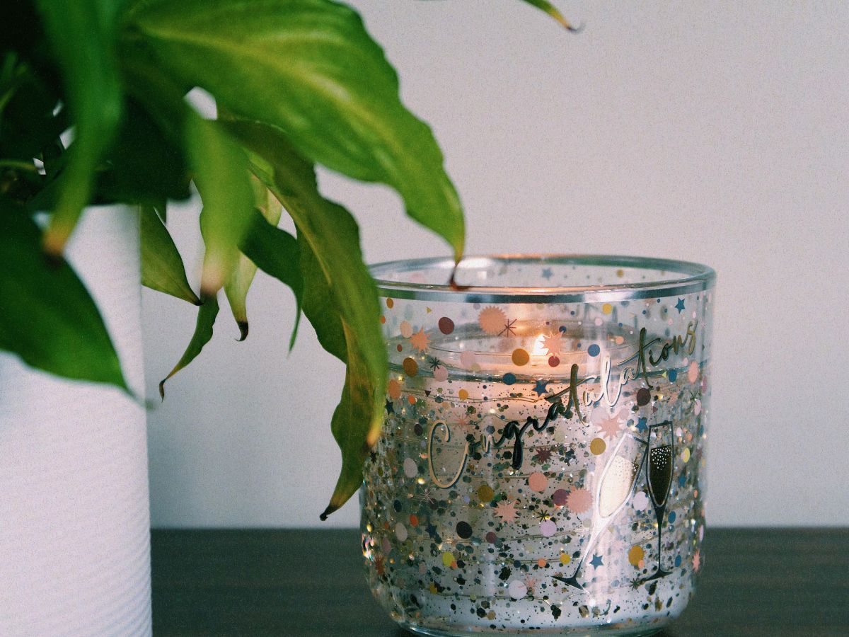 A decorative photograph of a candle that has 'Congratulations' printed on it, signifying contemplation on setting goals for the new year